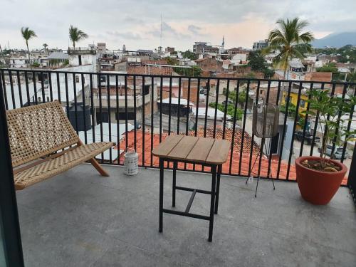 a bench and a table on a balcony with a view at Mako 54 in Puerto Vallarta
