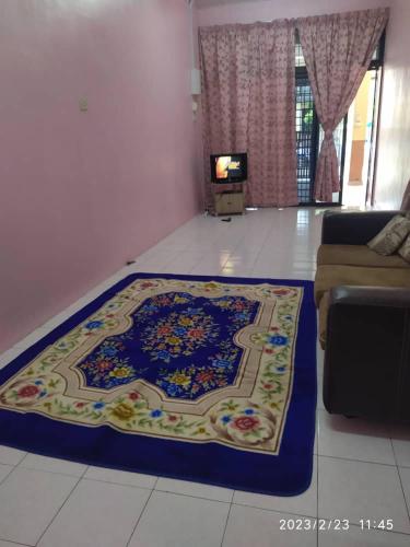 ein Wohnzimmer mit einem großen Teppich auf dem Boden in der Unterkunft BONDA HOMESTAY in Kampung Gurun