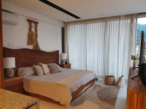 a bedroom with a large bed and a large window at Mako 54 in Puerto Vallarta