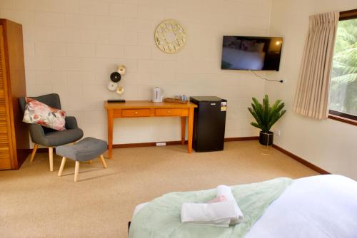 a bedroom with a desk and a table and a chair at Green Gables Warburton - King Garden Suite in Warburton