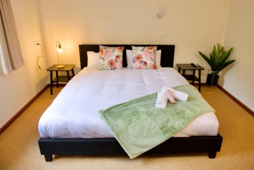 um quarto com uma cama grande e toalhas em Green Gables Warburton - King Garden Suite em Warburton