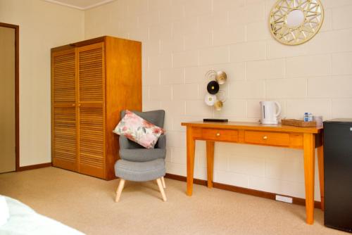 a bedroom with a desk and a chair and a table at Green Gables Warburton - King Garden Suite in Warburton