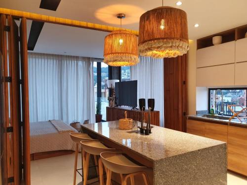a kitchen with a island with bar chairs and chandeliers at Mako 54 in Puerto Vallarta