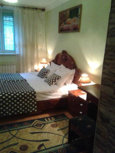 a bedroom with a bed and a desk with two lamps at Lux Apartment in Yerevan
