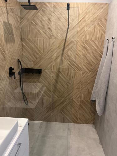 łazienka z prysznicem i drewnianą ścianą w obiekcie Marcinkowskiego 11 - 3 w mieście Katowice