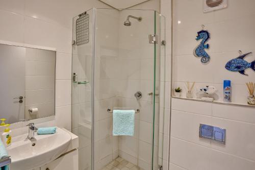 y baño con ducha y lavamanos. en Zimbali Lakes Boulevard Suites 103, en Ballito