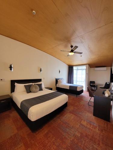 a bedroom with a bed and a couch and a ceiling at City of Sails Motel in Auckland