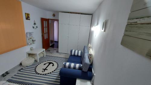 sala de estar con sofá azul y alfombra en Studio Olimp Black Sea, en Olimp