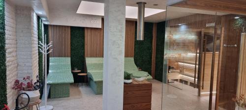 a lobby with a green bench and plants at Park Hotel Viasport in Gorni Dŭbnik