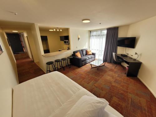 Habitación de hotel con cama y sala de estar. en City of Sails Motel, en Auckland