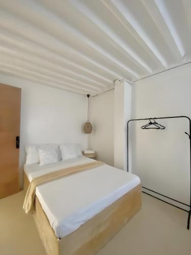 a white bedroom with a bed and a white ceiling at New Modern Suite Near Airport & Beach in Sudtungan