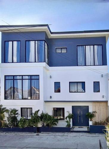 a large blue and white house with windows at New Modern Suite Near Airport & Beach in Sudtungan