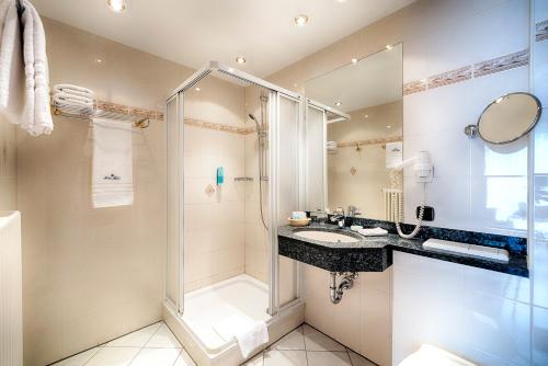 a bathroom with a shower and a sink at Hotel Villa Heine Wellness & Spa in Halberstadt