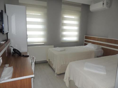 a hotel room with two beds and a window at Sogutpark Hotel in Trabzon
