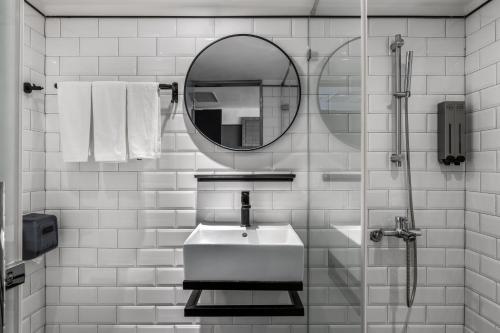 een witte badkamer met een wastafel en een spiegel bij Jia's Inn Kenting in Hengchun