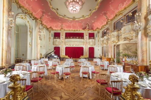 einen Bankettsaal mit weißen Tischen und roten Stühlen in der Unterkunft Grand Hotel Bohemia in Prag