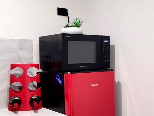 a microwave oven sitting on top of a red refrigerator at Beachside One Bedroom Flat Retreat in Maroochydore