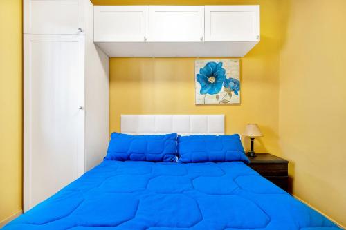 a bed with blue pillows in a bedroom at Maria I Apartment with private pool in Torrevieja
