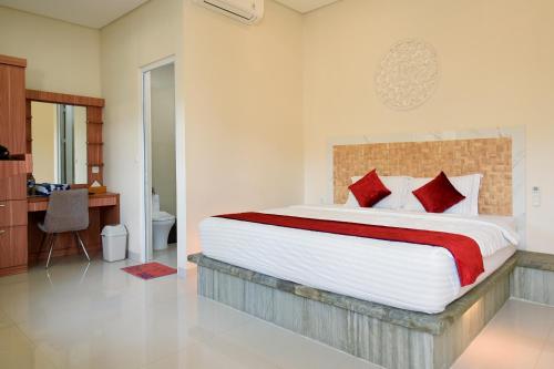 a bedroom with a large bed with red pillows at Seamount Hotel Amed in Amed