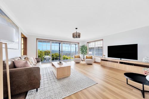 a living room with a flat screen tv and a couch at Bateau Family Retreat - Magical sunset views in Bateau Bay