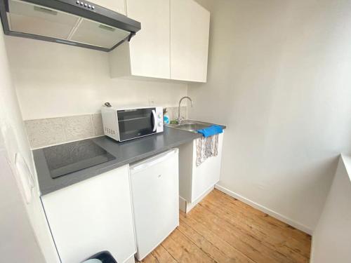uma pequena cozinha com um lavatório e um micro-ondas em Le P Tillant avec salle de sport em Amiens