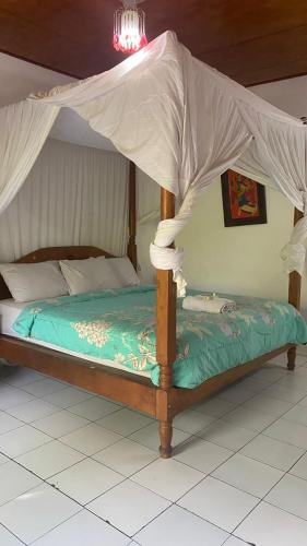 a bed with a canopy in a room at Barclona Guesthouses Lovina in Buleleng