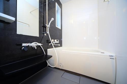 a bathroom with a white bath tub next to a window at 柏・二条1（Haku Nijo1） in Kyoto