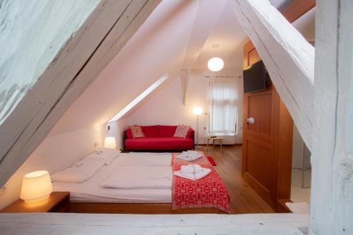 Habitación con cama y sofá rojo en Pr'Gavedarjo Eco Heritage B&B en Kranjska Gora