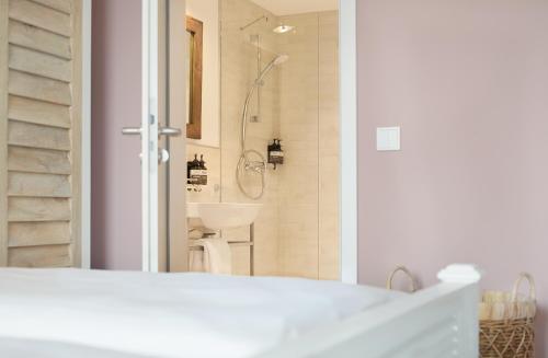 a bathroom with a shower and a white sink at Beach Apartments Büsum in Büsum