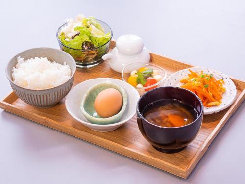 un vassoio di legno con ciotole di cibo sopra di Hotel Classe Stay Chitose a Chitose