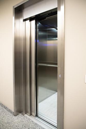 a glass elevator door in a building at Appartamenti Del Borgo in Borgosesia