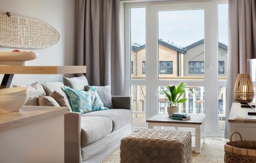 a living room with a couch and a large window at Beach Apartments Büsum in Büsum