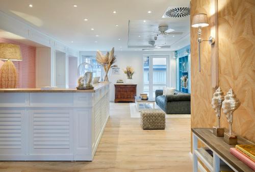 a living room with a kitchen and a living room with a couch at Beach Apartments Büsum in Büsum