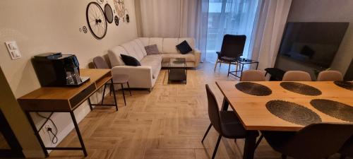 a living room with two tables and a couch at Apartament I Młyny Gdańskie blisko centrum in Gdańsk