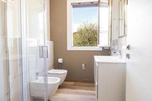 a bathroom with a toilet and a sink and a window at Appartamenti Del Borgo in Borgosesia