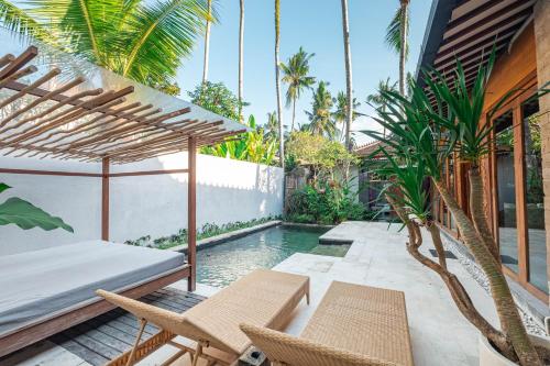 an outdoor patio with chairs and a swimming pool at Kakul Villas & Suites in Ubud
