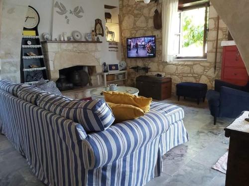 a living room with a couch and a fireplace at Aliki's House 1+ 2 in Polis Chrysochous