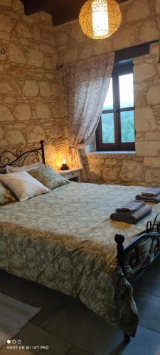 a bedroom with a large bed in a stone wall at Aliki's House 1+ 2 in Polis Chrysochous