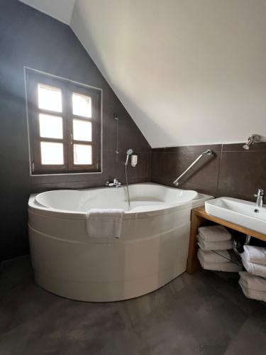 a bathroom with a large tub and a sink at Hotel Strk in Murska Sobota