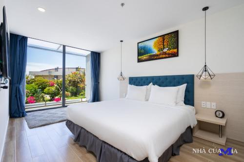 a bedroom with a large bed and a large window at MIA Beach Villa - Oceanami Resort Long Hai Vung Tau in Long Hai