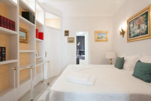 - une chambre blanche avec un grand lit blanc et des étagères dans l'établissement Cannes Meynadier: Superbe appartement trois pièces, à Cannes