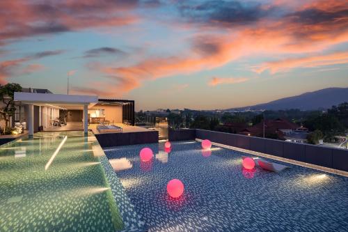 a swimming pool with pink lights on top of a house at Travelodge Nimman in Chiang Mai