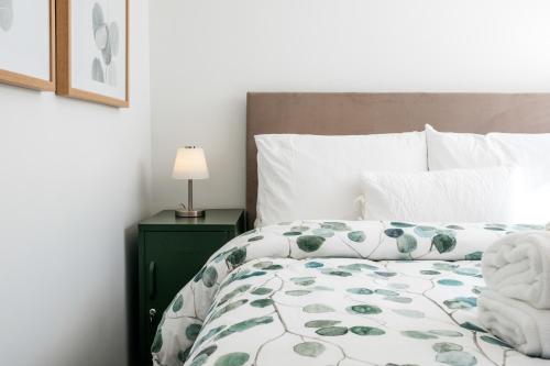 a bedroom with a bed with a green night stand at Oneroa Coastal Classic - Coast & Country in Oneroa