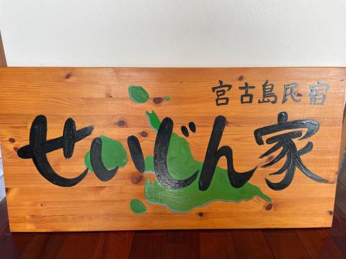 Una señal para un restaurante con escritura japonesa. en 一棟貸しの宿 民宿せいじん家, en Isla Miyako
