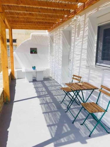 a porch with two chairs and a desk on a house at New, Modern and Cozy apartment in Gavrio in Gavrion