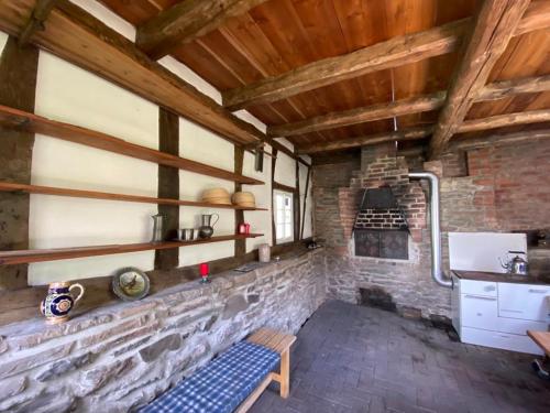 sala de estar con chimenea de piedra y banco en Ferienwohnung am alten Backhaus, en Bad Berleburg