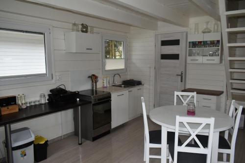 a kitchen with a table and a table and chairs at Domki nad jeziorem Kazub in Cieciorka