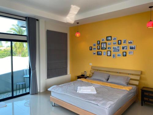 um quarto com uma cama e uma parede amarela em Cordelia Resort Sam Roi Yot em Sam Roi Yot