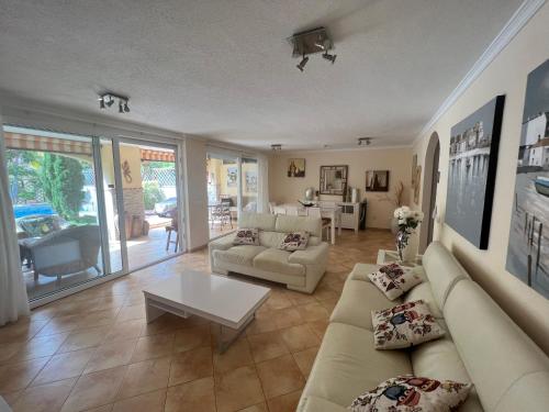 a living room with a couch and a table at Villa with private pool and beautiful garden in Los Cristianos