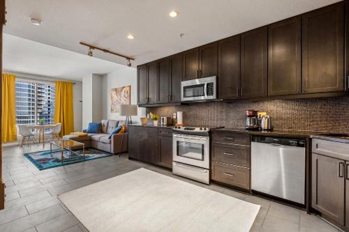 cocina con electrodomésticos de acero inoxidable y sala de estar. en City View 1BR Downtown Calgary en Calgary